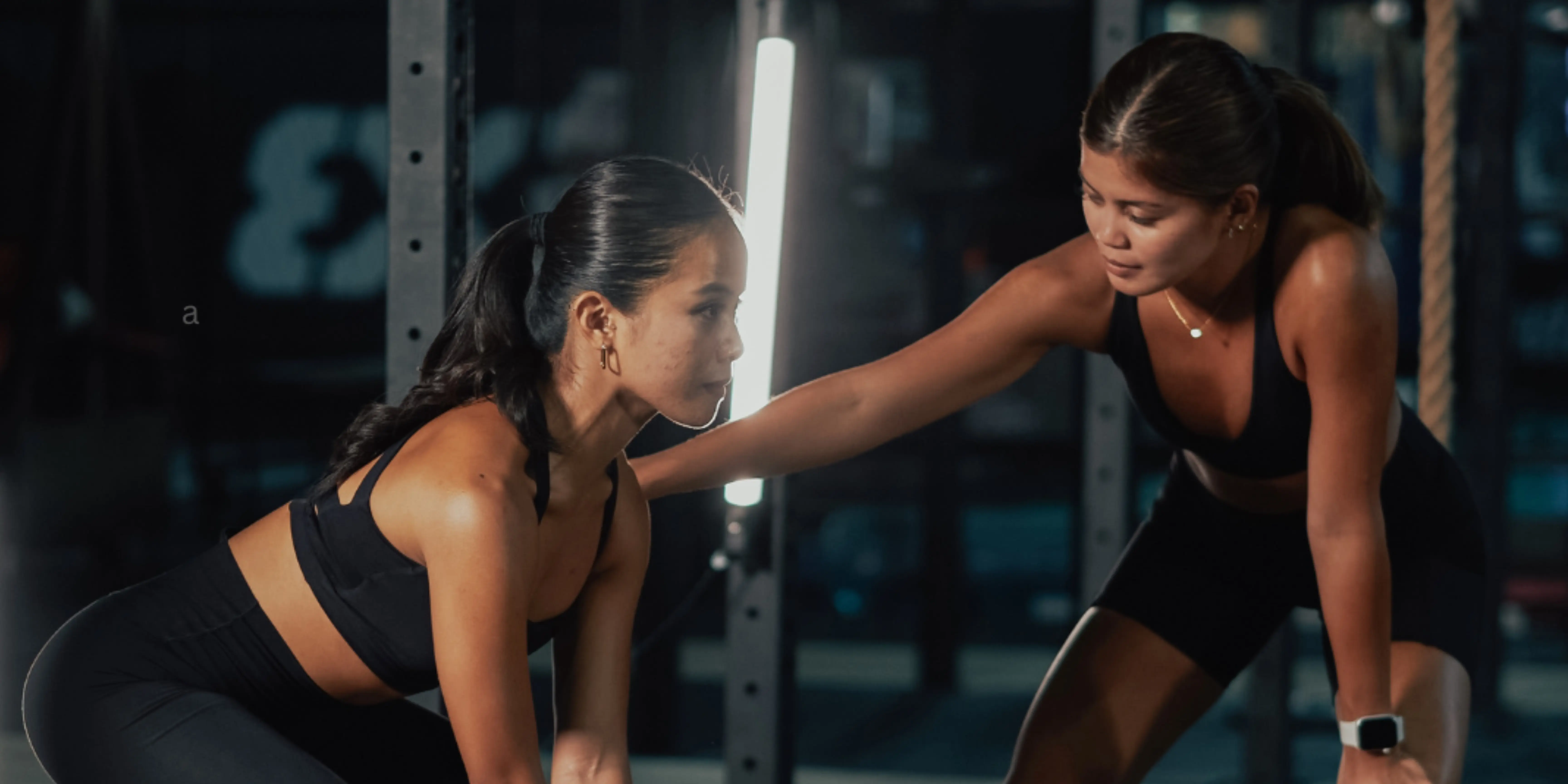 female trainer train other female in a gym setup